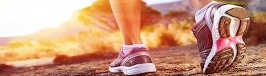 The Walking Series Awareness Through Movement Program Product Image shows a woman's legs walking in running shoes on a wilderness, desert trail.