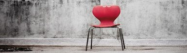 Finding Your Seat Awareness Through Movement Program in the Feldenkrais Method product image of a red chair in a grey room.